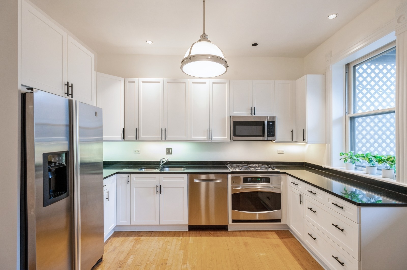 1643 West Julian Street Chicago, IL 60622 - Photo 6 of 20 a kitchen with stainless steel appliances granite countertop a stove a sink and a refrigerator with wooden floors