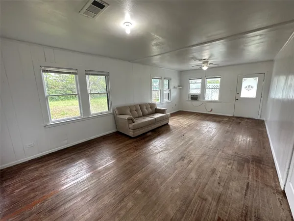 a living room with furniture and a hard wood floor