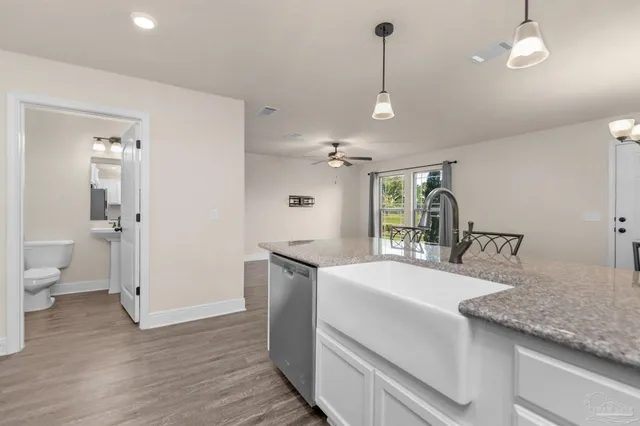 a large white kitchen with a stove a sink and dishwasher