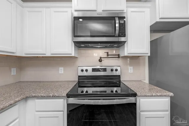a stove top oven sitting inside of a kitchen