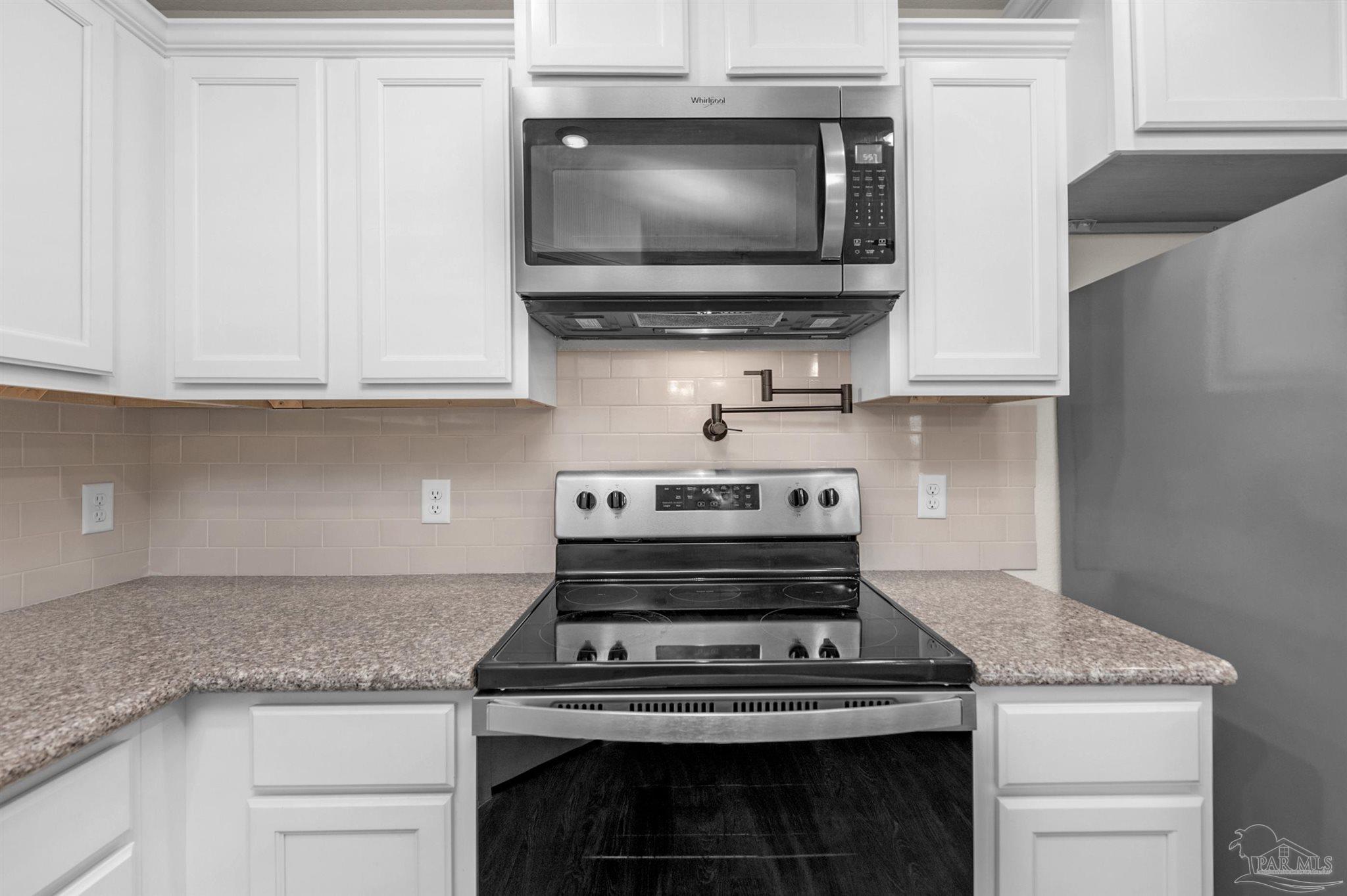 5069 Peach Drive Pace, FL 32571 - Photo 12 of 41 a stove top oven sitting inside of a kitchen