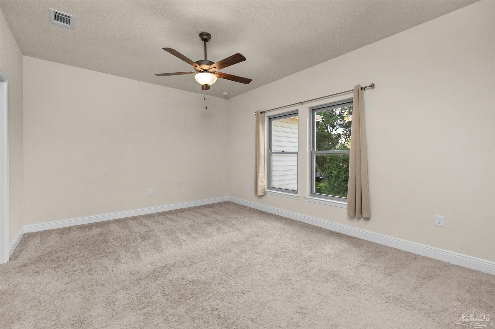5069 Peach Drive Pace, FL 32571 - Photo 14 of 41 a view of a big room with windows and chandelier fan