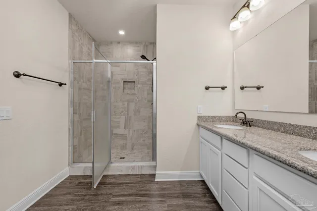 a bathroom with a granite countertop sink a toilet and shower