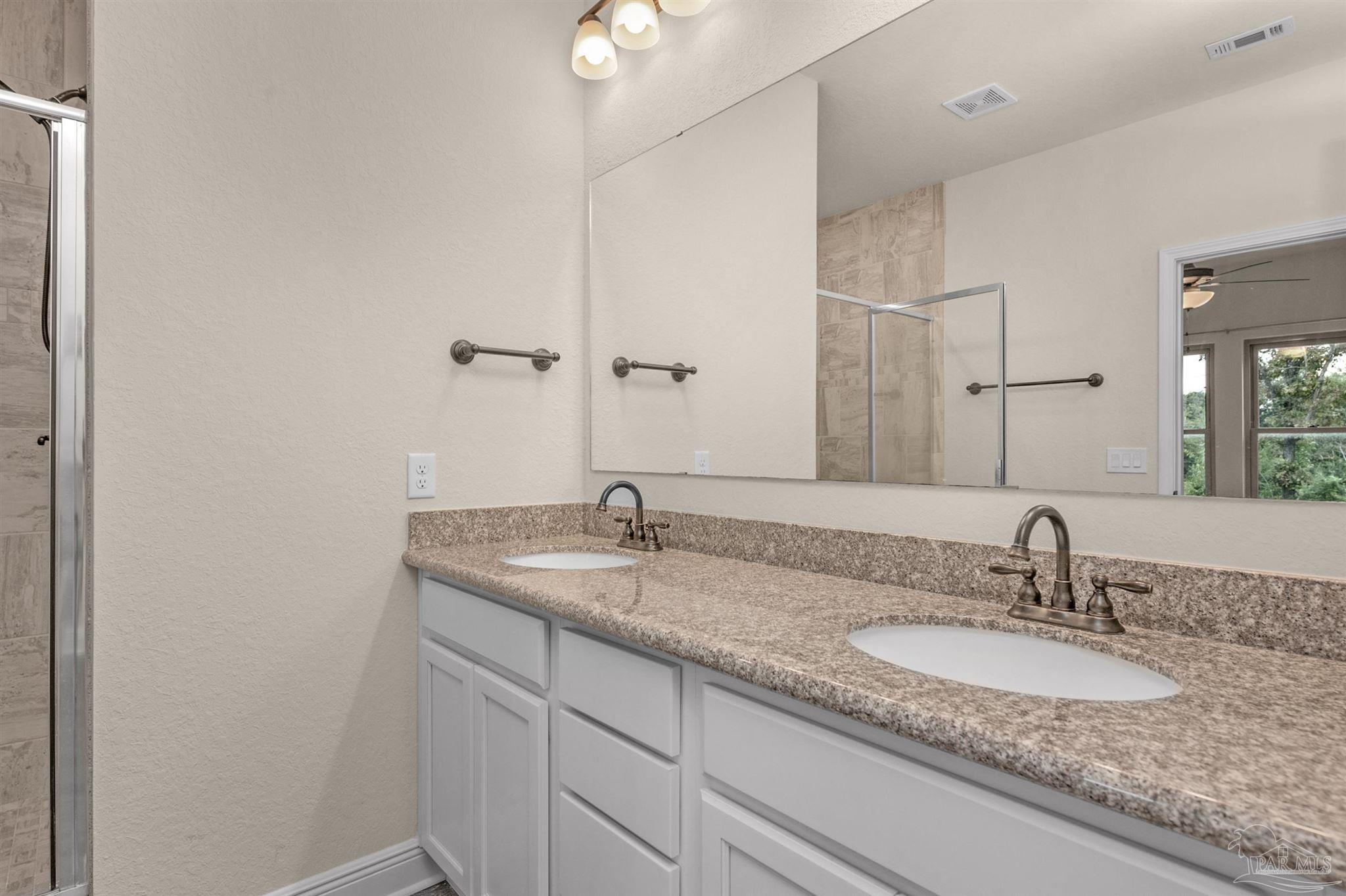 5069 Peach Drive Pace, FL 32571 - Photo 19 of 41 a bathroom with a granite countertop sink and a mirror