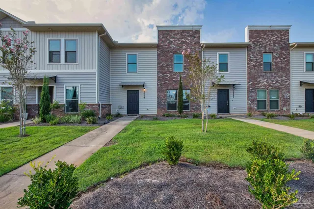 a view of a house with a yard and a large tree