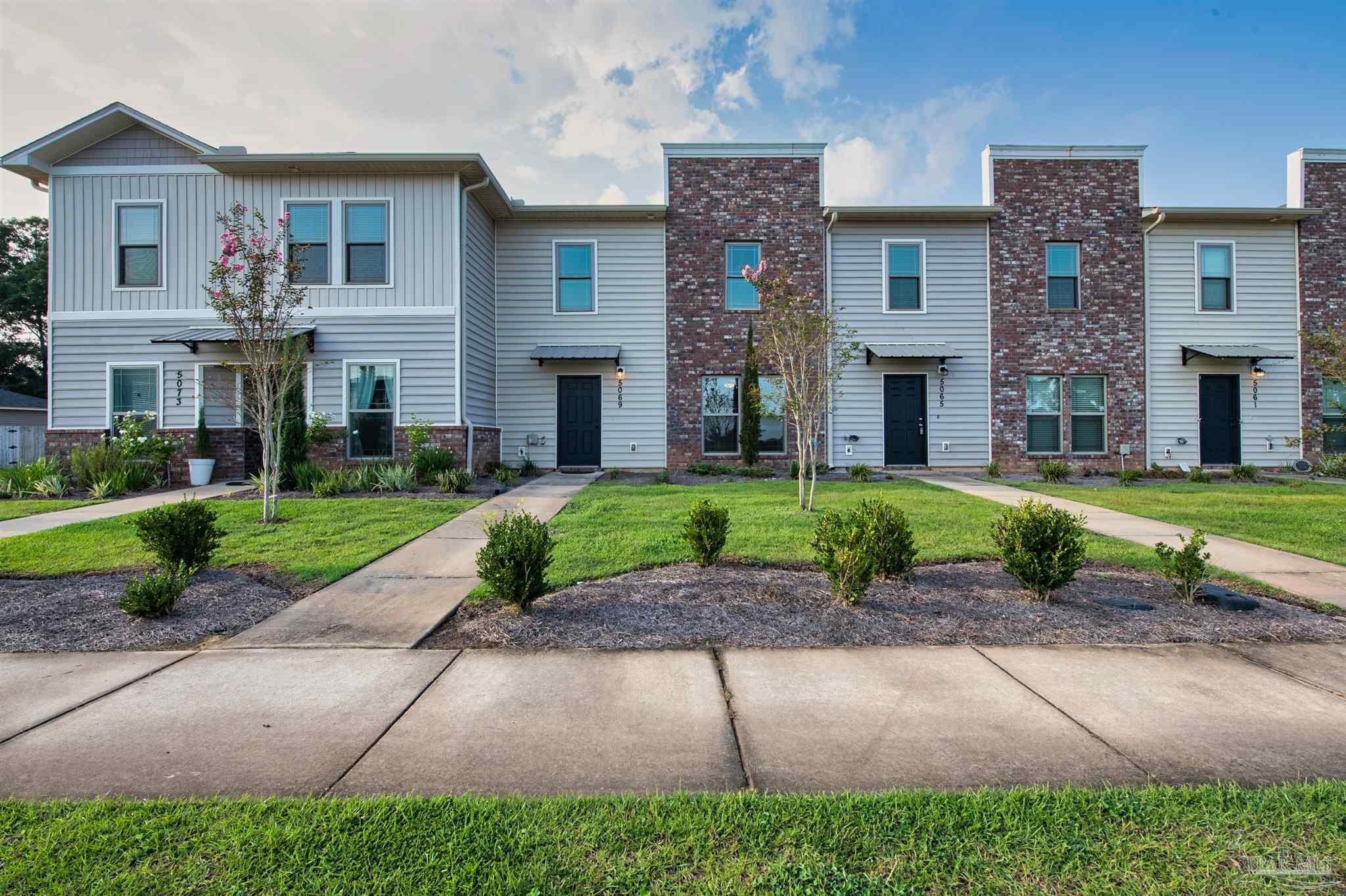 5069 Peach Drive Pace, FL 32571 - Photo 41 of 41 a front view of a house with a garden and plants