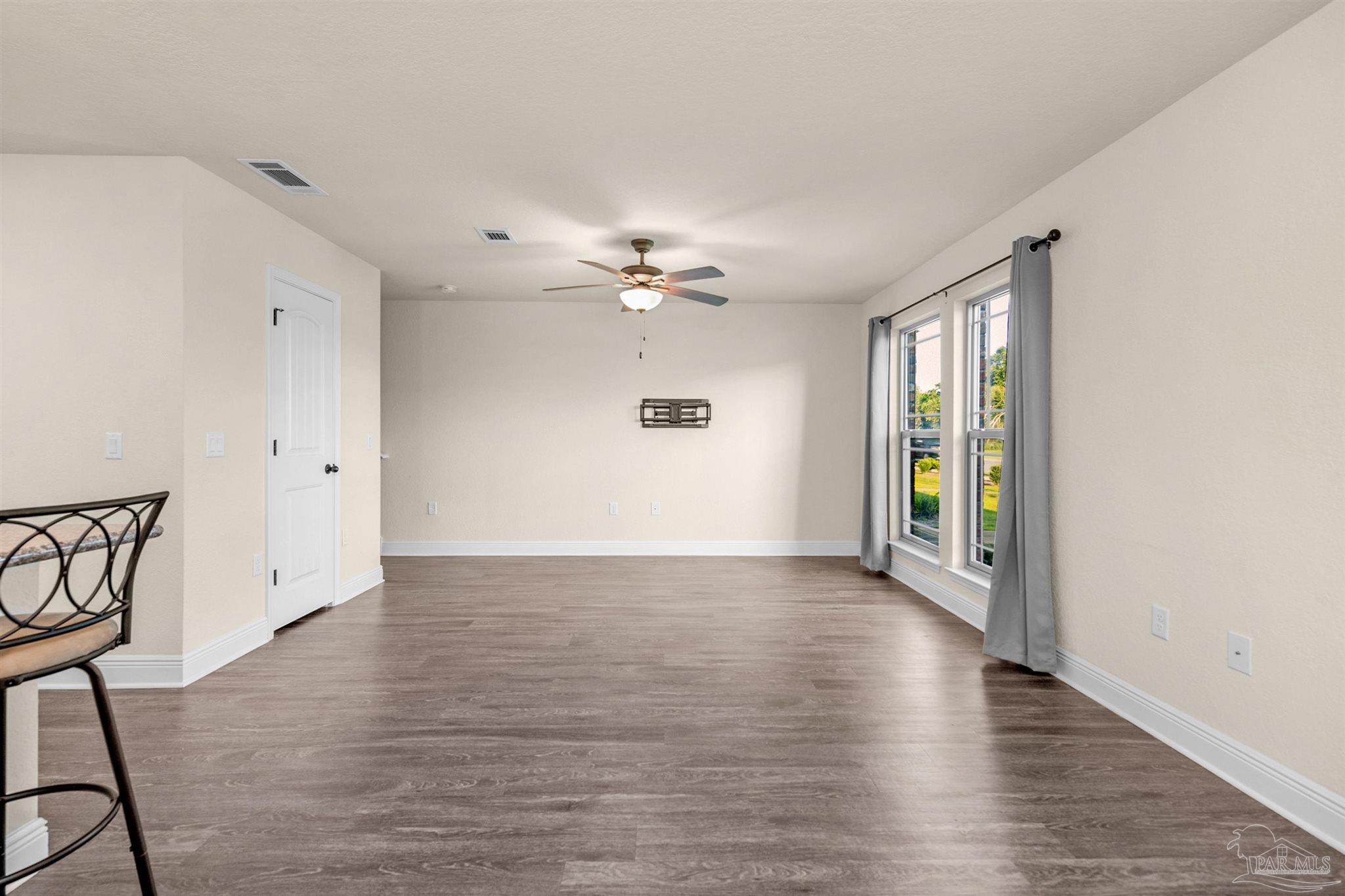 5069 Peach Drive Pace, FL 32571 - Photo 5 of 41 a view of an empty room with a window and wooden floor