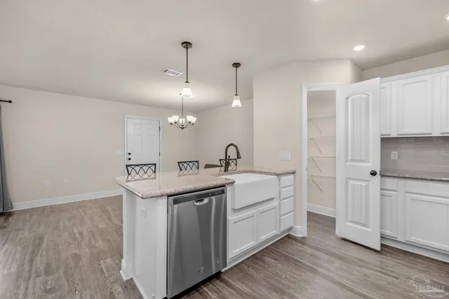 a kitchen with a sink cabinets and wooden floor