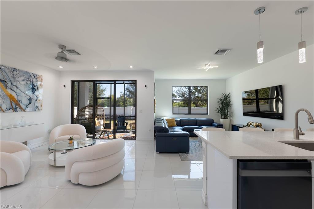 Living room with light tile patterned floors and recessed lighting
