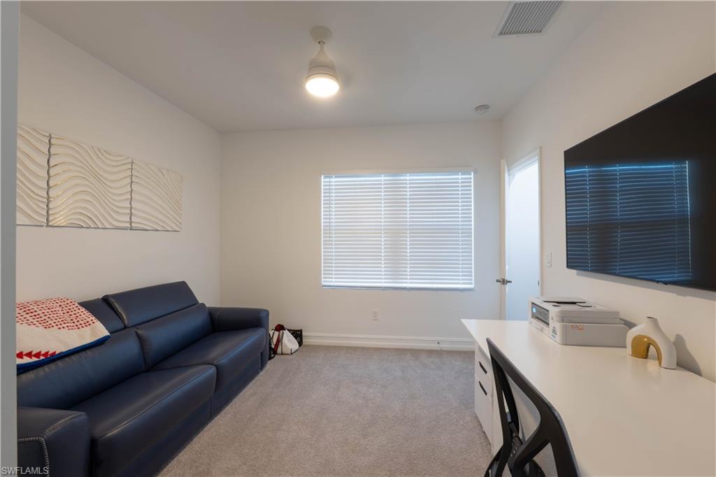 7510 Rockefeller Drive Naples, FL 34119 - Photo 29 of 31 Living area with light carpet and a desk