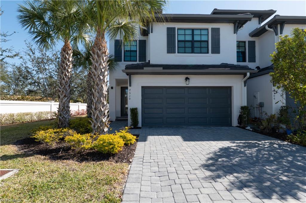 7510 Rockefeller Drive Naples, FL 34119 - Photo 10 of 31 View of front of house with stucco siding, an attached garage, and decorative driveway