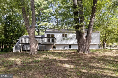 a view of a house with a large tree and a yard