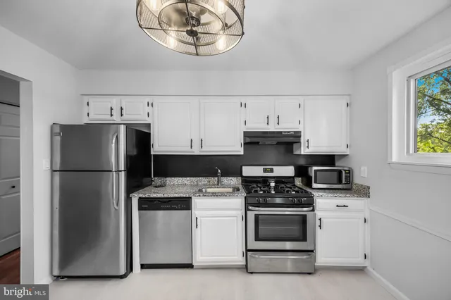 a kitchen with cabinets appliances and a window