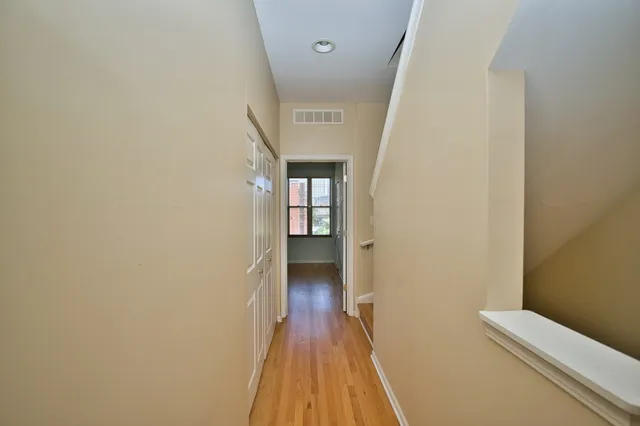 a view of a hallway with wooden floor and staircase