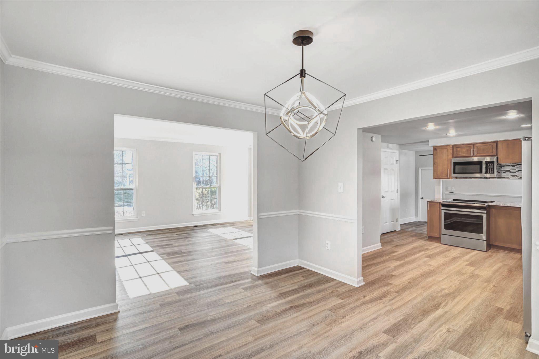 1324 Rock Chapel Road Herndon, VA 20170 - Photo 10 of 42 a view of a livingroom with wooden floor kitchen view and a chandelier