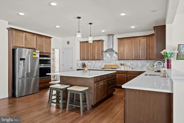 a kitchen with stainless steel appliances granite countertop a table chairs sink refrigerator and microwave