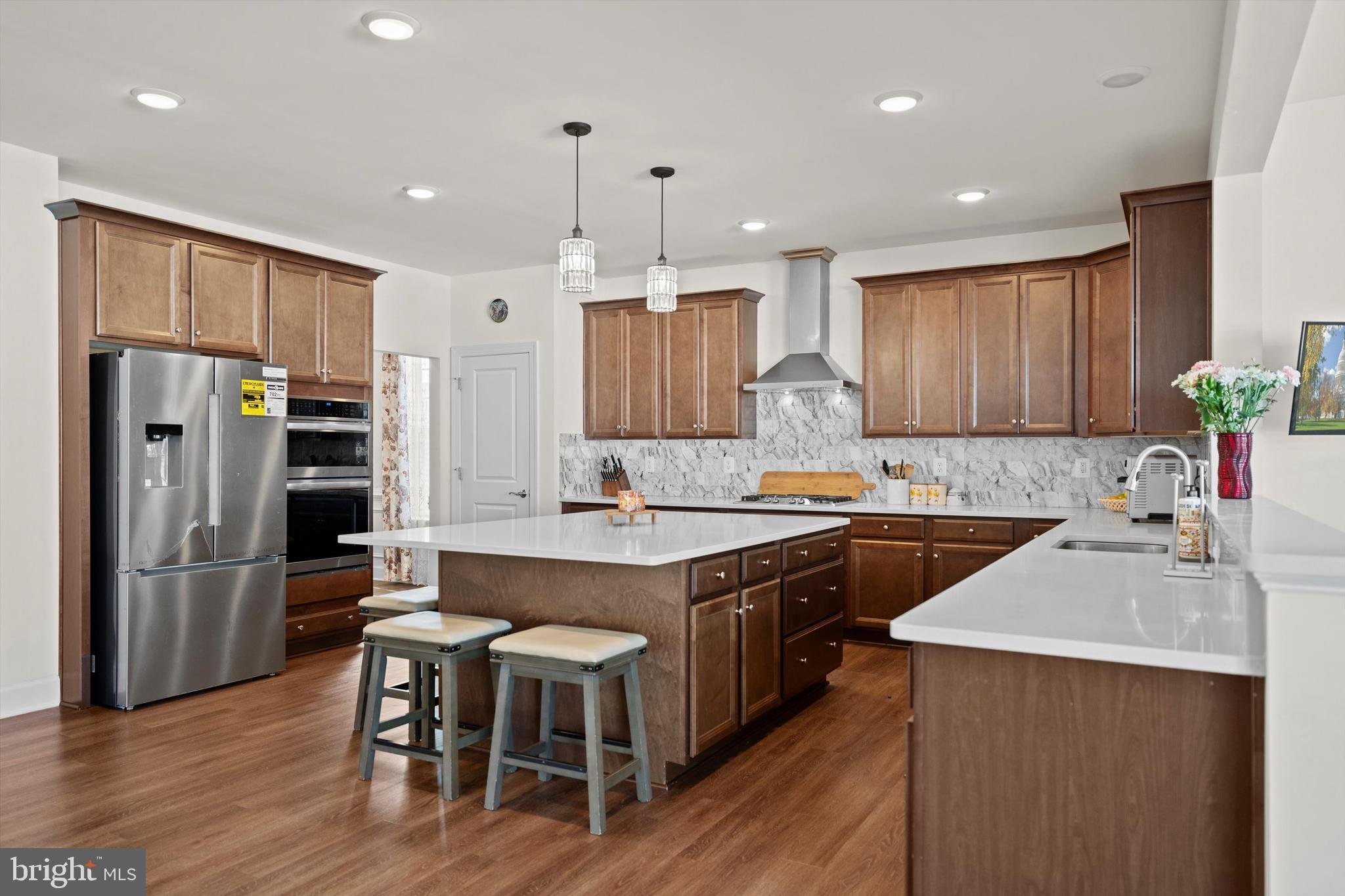 8690 Belle Grove Way Manassas, VA 20110 - Photo 12 of 55 a kitchen with stainless steel appliances granite countertop a table chairs sink refrigerator and microwave