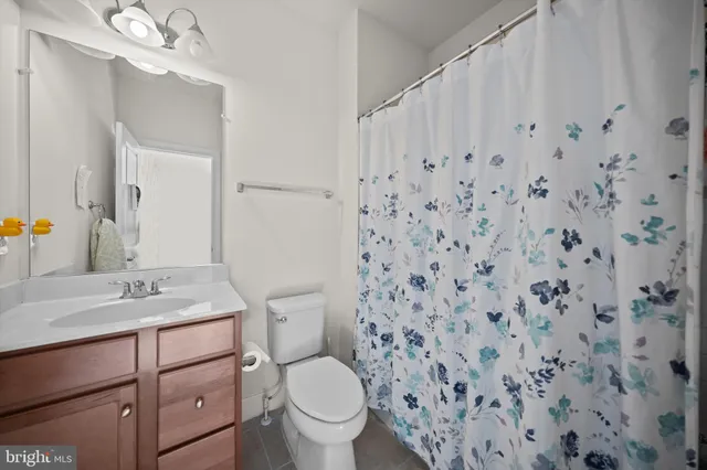 a bathroom with a granite countertop sink mirror vanity and toilet