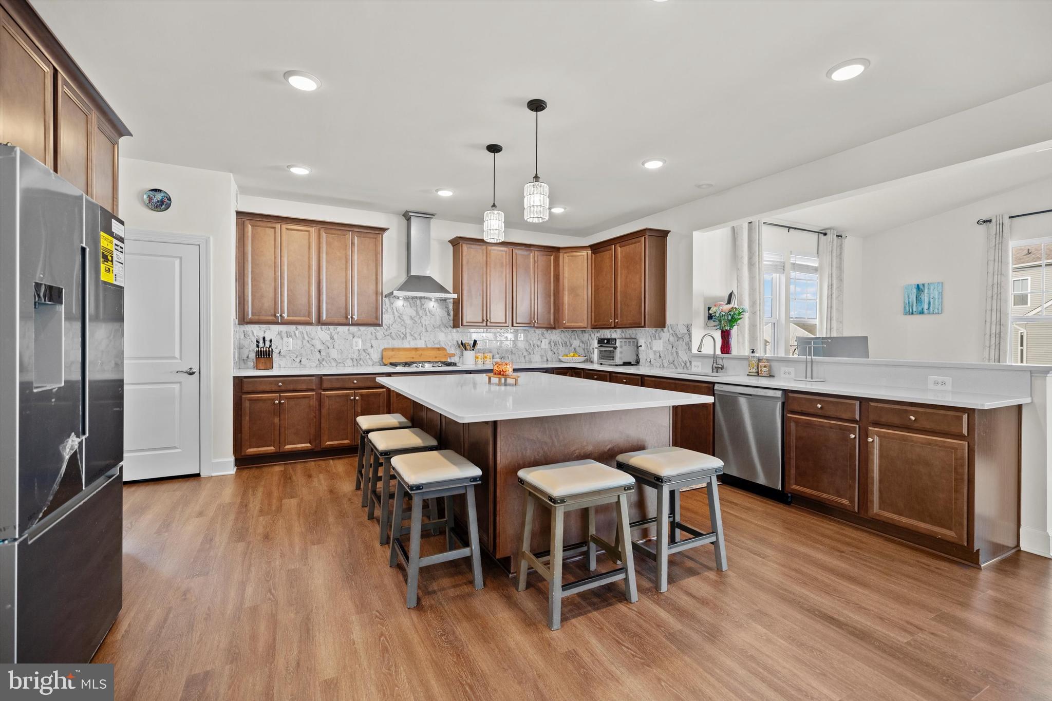 8690 Belle Grove Way Manassas, VA 20110 - Photo 10 of 55 a kitchen with kitchen island granite countertop wooden floors and white stainless steel appliances