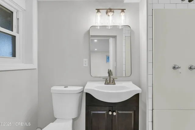 a bathroom with a toilet sink and mirror