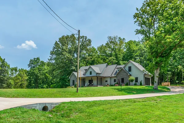 a front view of a house with a yard and trees