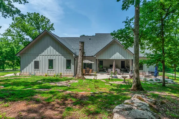 a front view of a house with a yard and trees