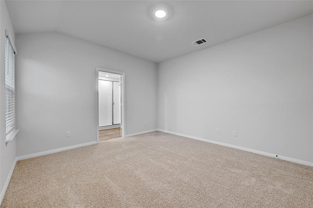 295 Evergreen Sumac Loop Kyle, TX 78640 - Photo 13 of 30 Empty room featuring light carpet and vaulted ceiling