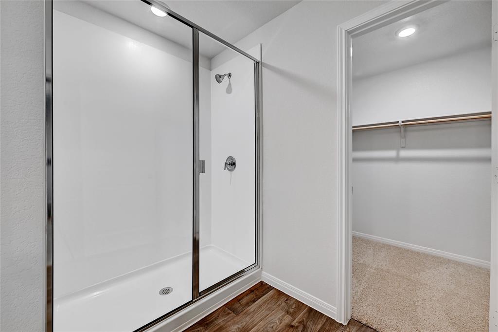 295 Evergreen Sumac Loop Kyle, TX 78640 - Photo 15 of 30 Full bath with a walk in closet, a stall shower, dark wood-style flooring, and recessed lighting