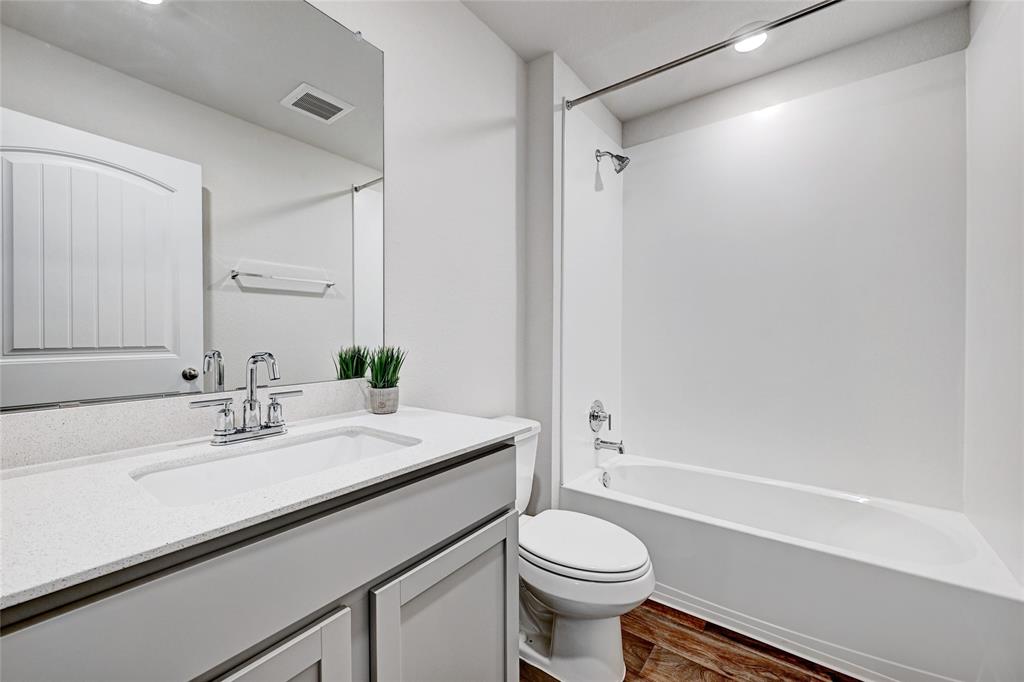 295 Evergreen Sumac Loop Kyle, TX 78640 - Photo 18 of 30 Full bathroom with vanity, dark wood-style floors, and tub / shower combination