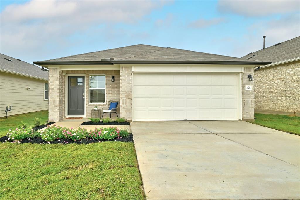 295 Evergreen Sumac Loop Kyle, TX 78640 - Photo 2 of 30 Ranch-style house featuring concrete driveway, a garage, brick siding, and a front lawn