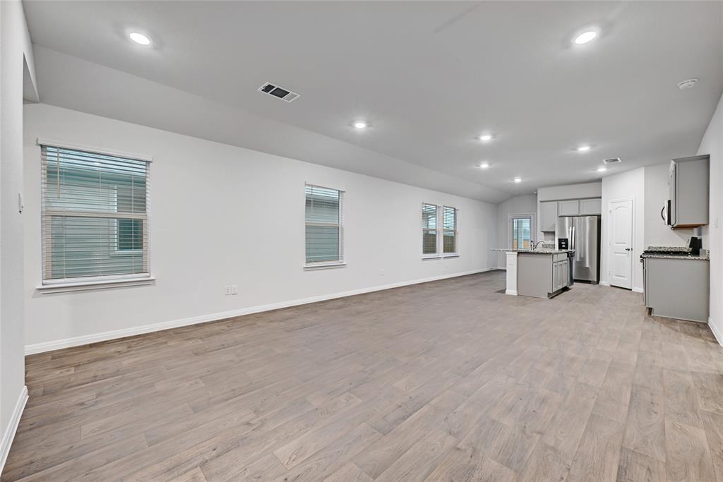 295 Evergreen Sumac Loop Kyle, TX 78640 - Photo 4 of 30 Unfurnished living room featuring lofted ceiling, light wood finished floors, and recessed lighting