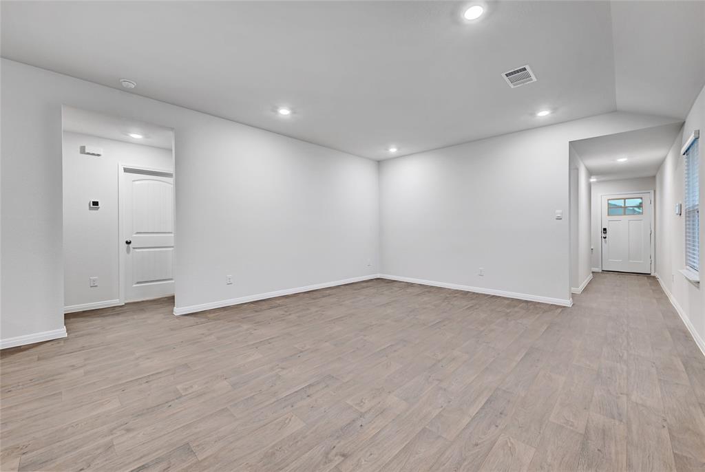 295 Evergreen Sumac Loop Kyle, TX 78640 - Photo 6 of 30 Empty room featuring light wood finished floors, recessed lighting, and lofted ceiling