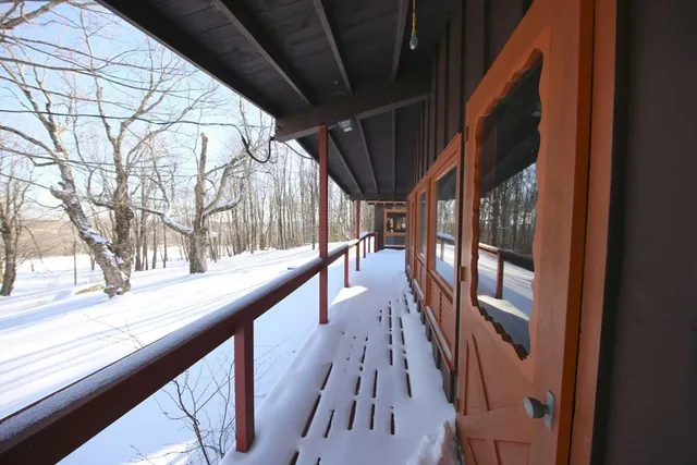 a view of empty room with wooden floor and fence