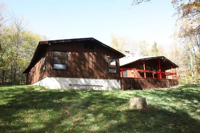 a view of a house with a small yard and wooden fence