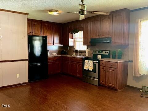 543 Stockyard Road Staley, NC 27355 - Photo 4 of 11 a kitchen with stainless steel appliances granite countertop wooden cabinets a refrigerator a sink a stove a microwave and wooden floors