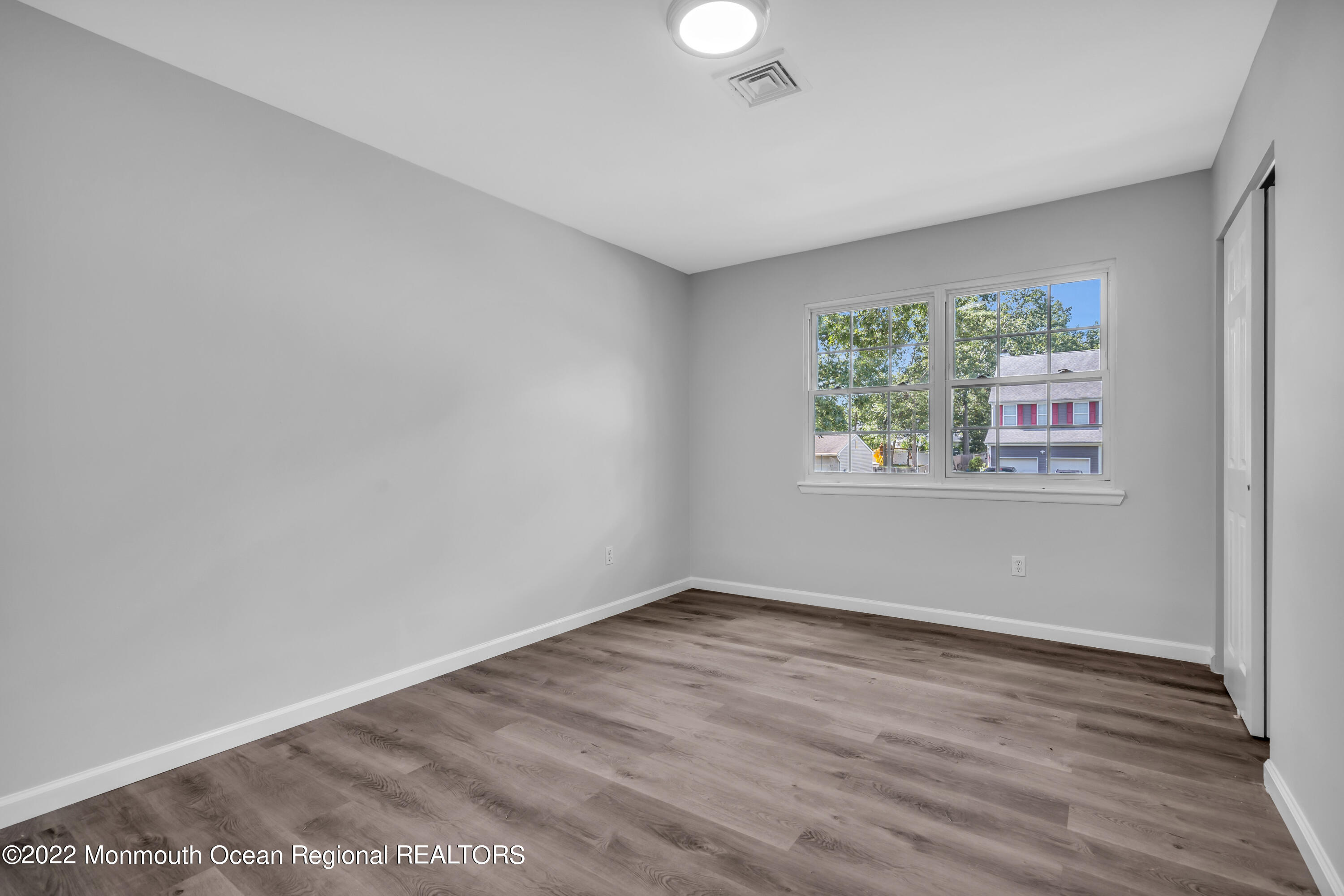 2440 Steiner Road Manchester Township, NJ 08759 - Photo 43 of 59 an empty room with wooden floor and windows