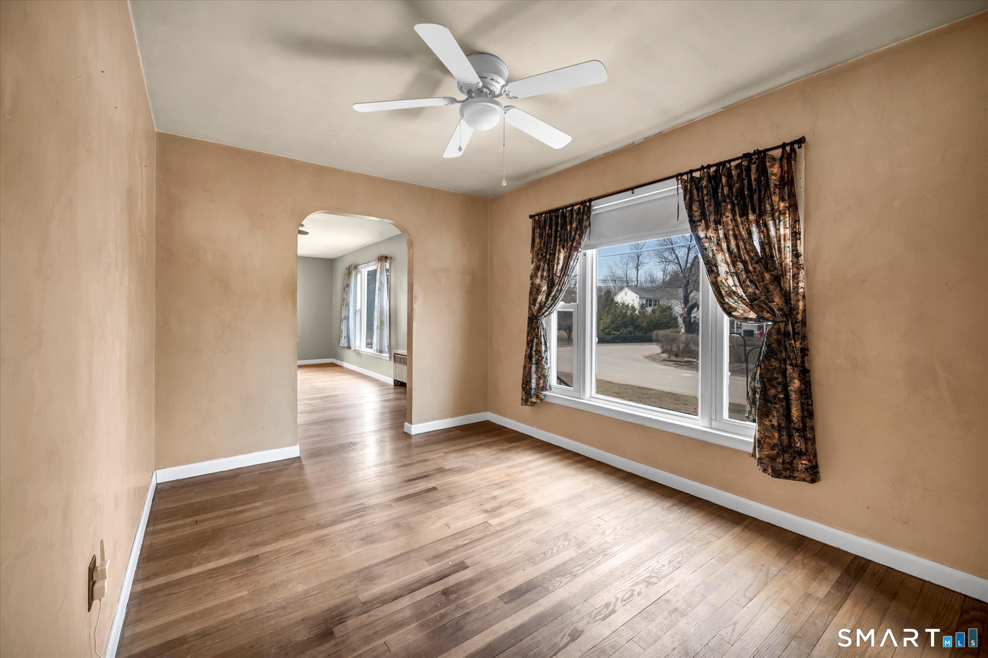 73 Sterling Hill Road Plainfield, CT 06354 - Photo 15 of 35 a view of a big room with wooden floor a ceiling fan and windows