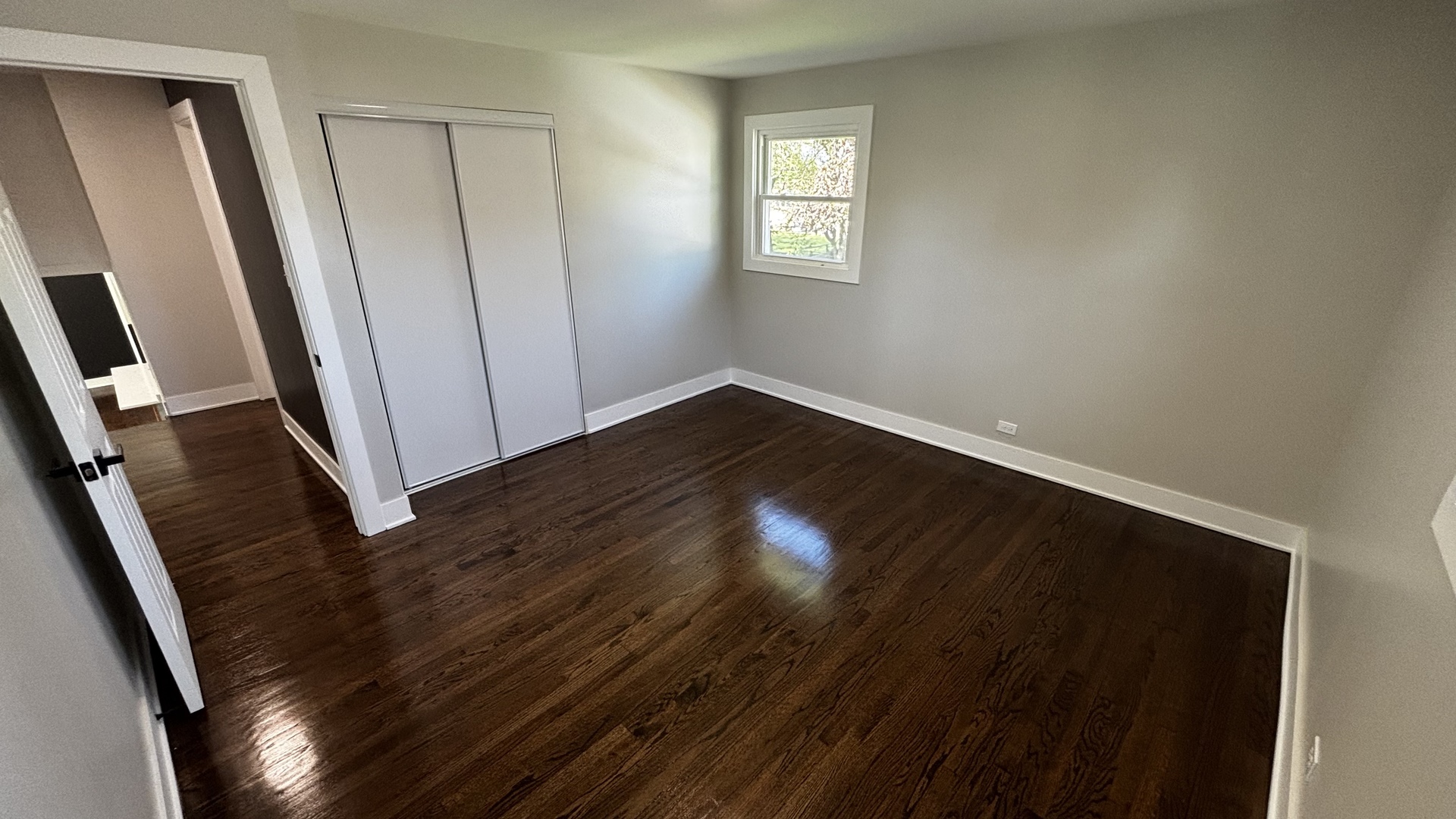 18314 Locust Street Lansing, IL 60438 - Photo 12 of 14 a view of an empty room with wooden floor and a window