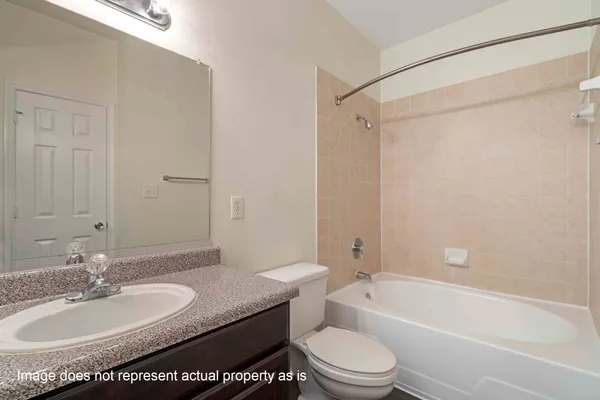 a bathroom with a granite countertop sink mirror toilet and bathtub