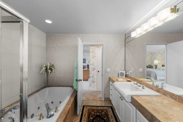 a bathroom with a tub sink and mirror