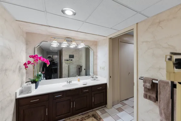 a bathroom with a granite countertop sink a large mirror and a shower