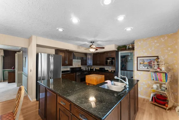 a kitchen with stainless steel appliances granite countertop a sink a stove and a refrigerator
