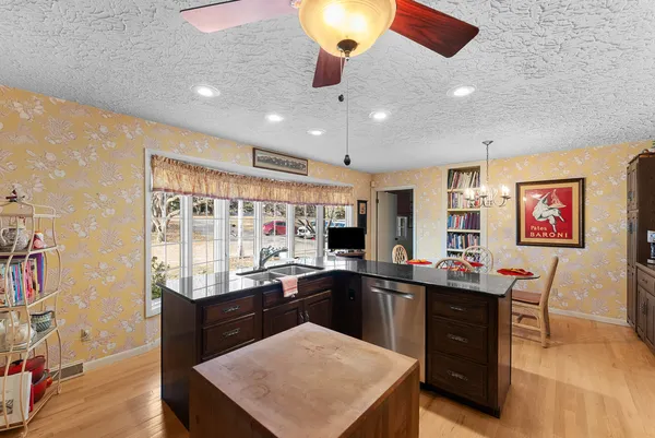 a kitchen with a sink a counter space dining table and chairs