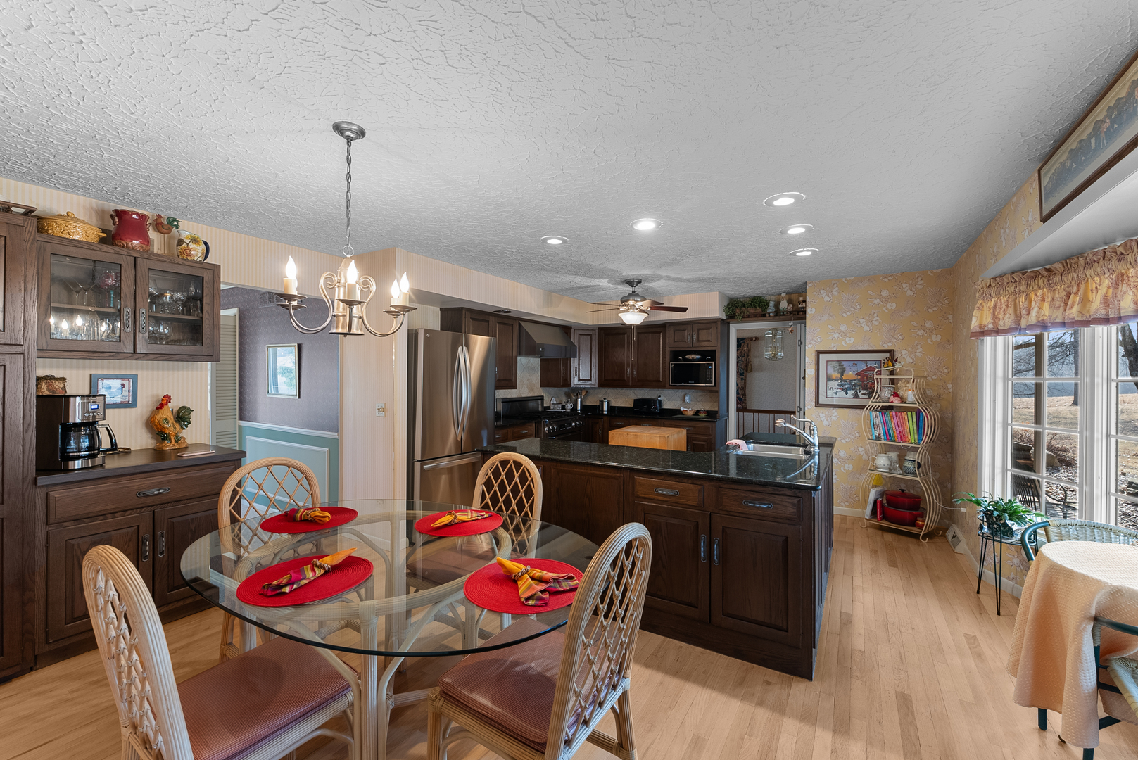 6026 95th Avenue West Taylor Ridge, IL 61284 - Photo 7 of 37 a kitchen with stainless steel appliances kitchen island granite countertop a dining table chairs and a refrigerator