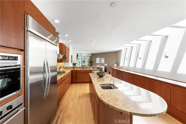a kitchen with stainless steel appliances granite countertop a sink a oven and a refrigerator