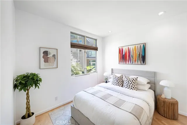 a bedroom with a bed and a large window with outer view