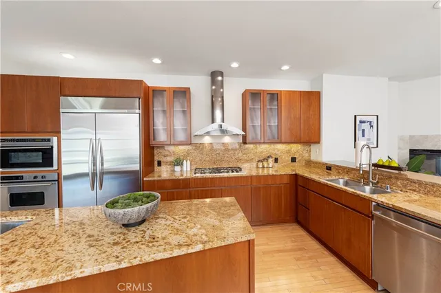 a kitchen with stainless steel appliances granite countertop sink stove and refrigerator