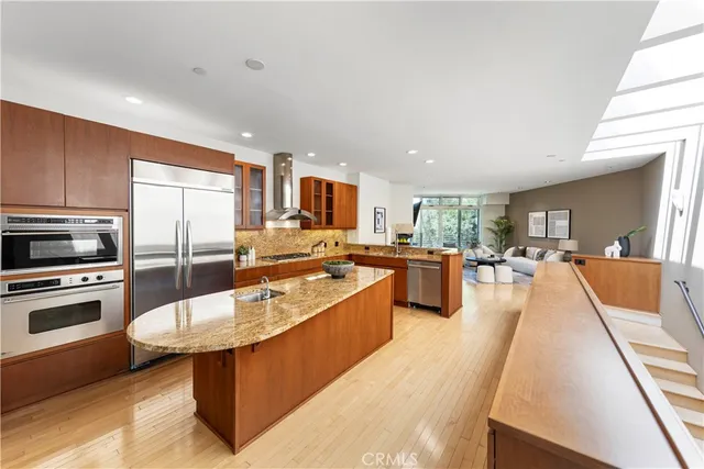 a large kitchen with kitchen island a large counter top appliances and cabinets