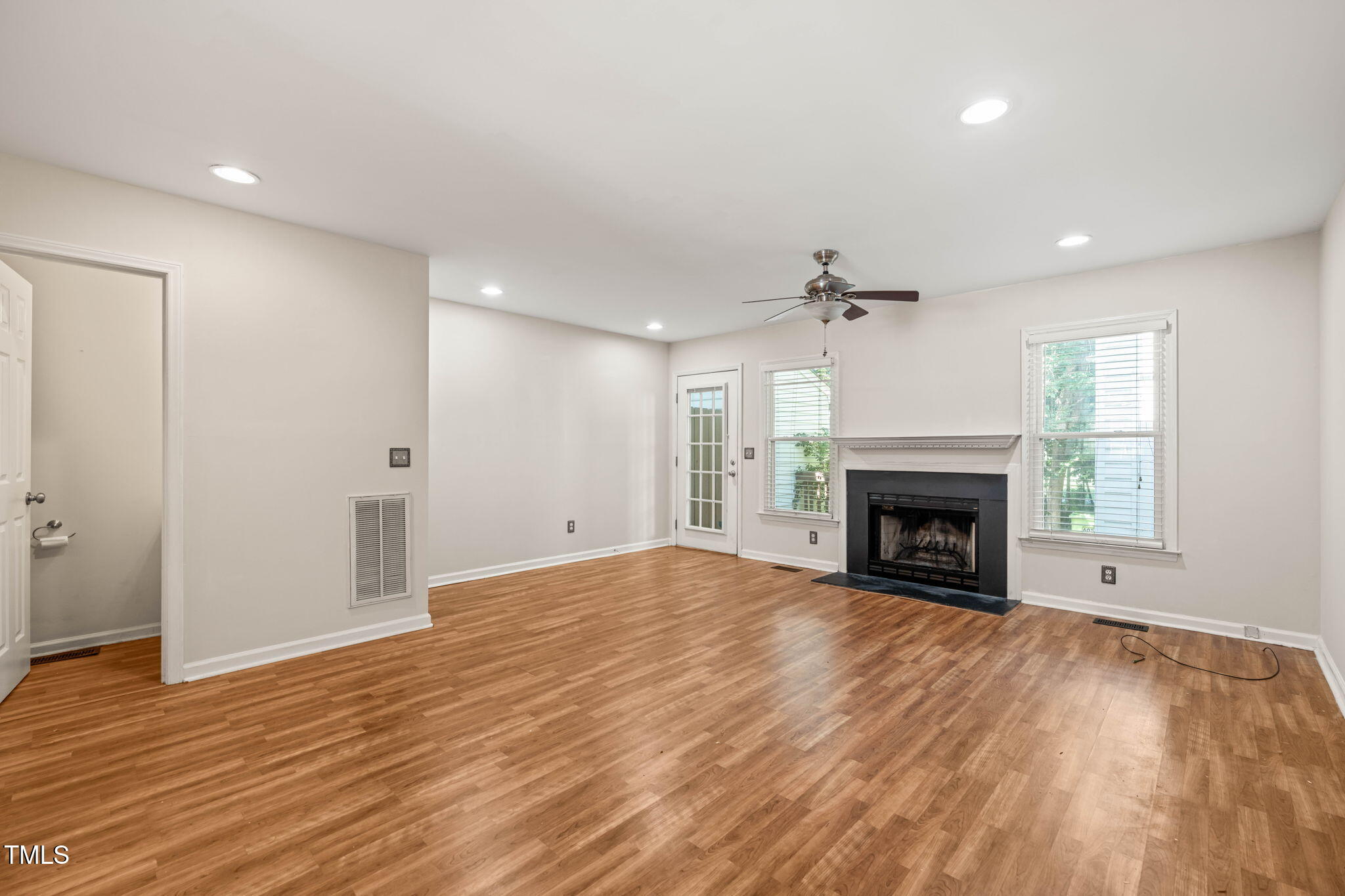 6051 Epping Forest Drive Raleigh, NC 27613 - Photo 1 of 26 a view of an empty room with wooden floor fireplace and a window
