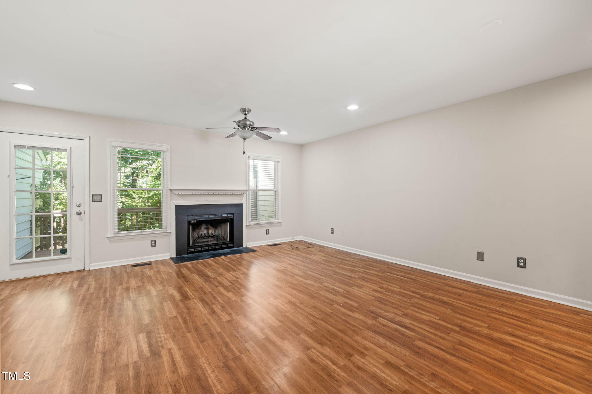 6051 Epping Forest Drive Raleigh, NC 27613 - Photo 2 of 26 a view of an empty room with wooden floor fireplace and a window